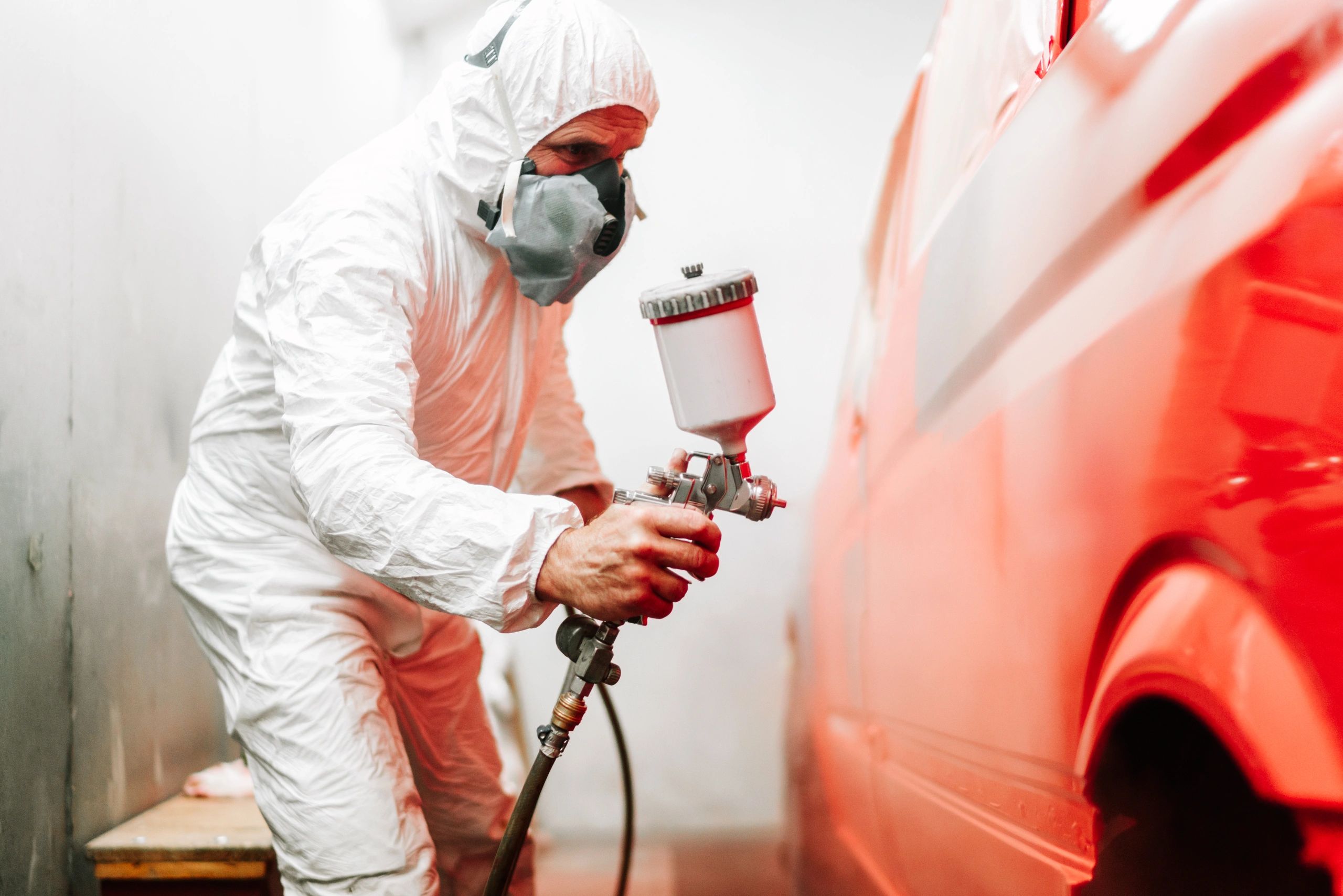 A picture of a car being painted in a pain spray booth at Autotexs.