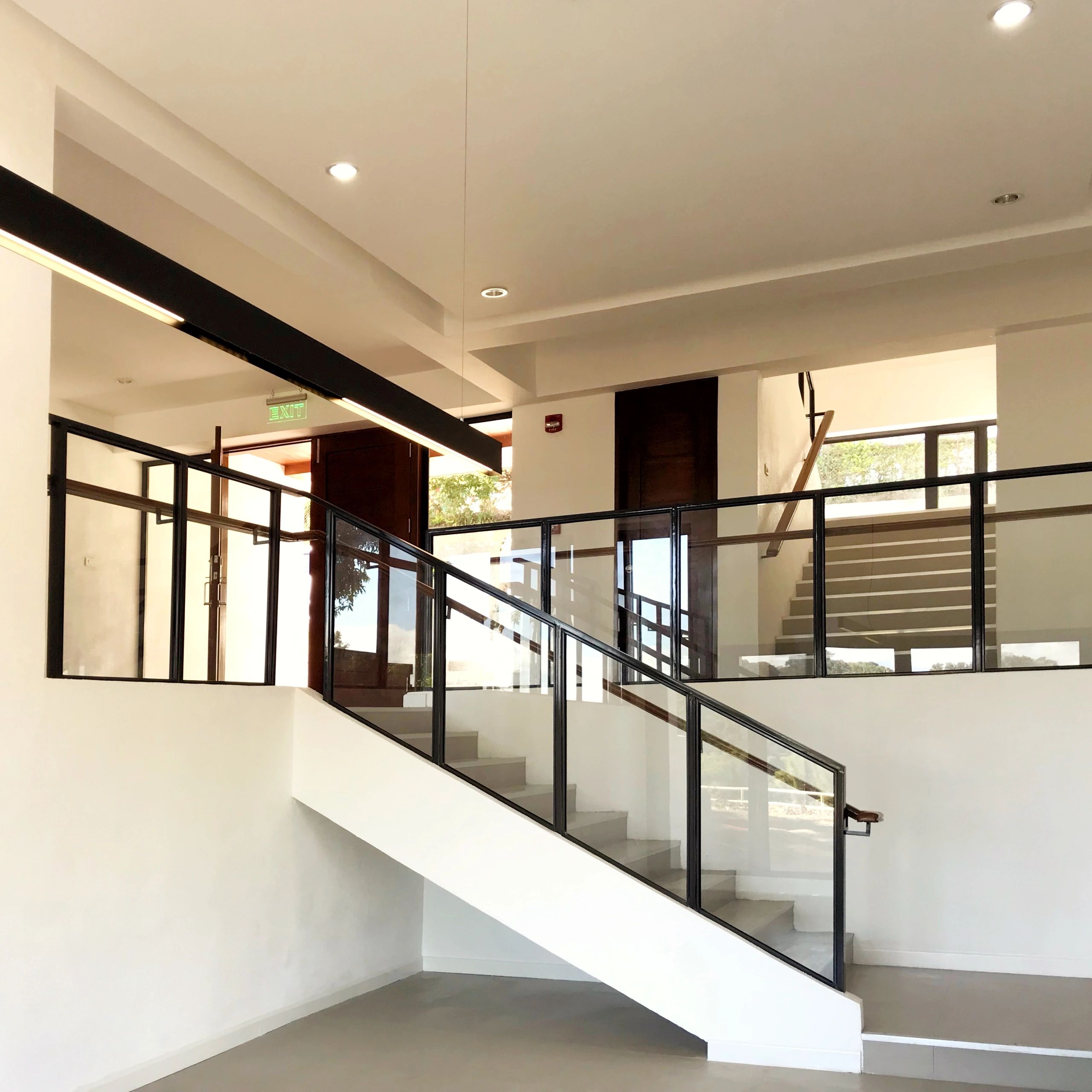 Modern indoor staircase with glass railings and natural light.