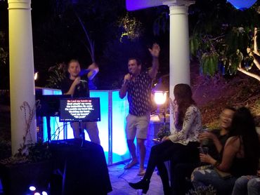 Two men singing karaoke while waving their hands