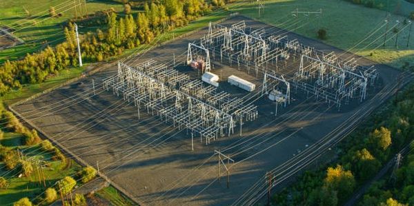Aerial view of an electrical substation surrounded by greenery.