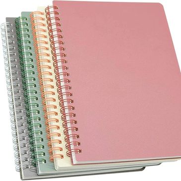 A stack of five spiral-bound notebooks in pastel colors with smooth covers.