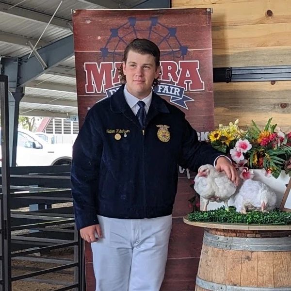 Nathan with a pair of Cornish Cross meat birds at fair. 