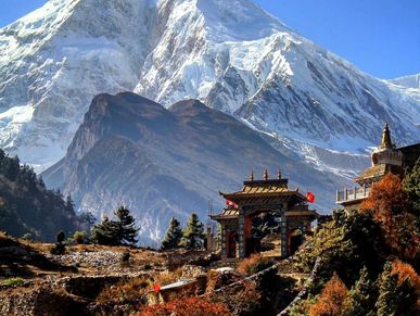 Traditional gate with snowy mountains in the background under a clear blue sky.