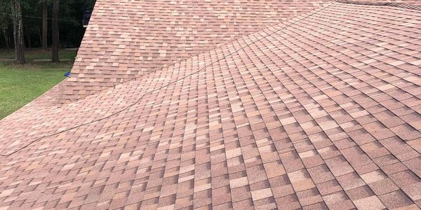 Newly installed brown shingle roof on a house.