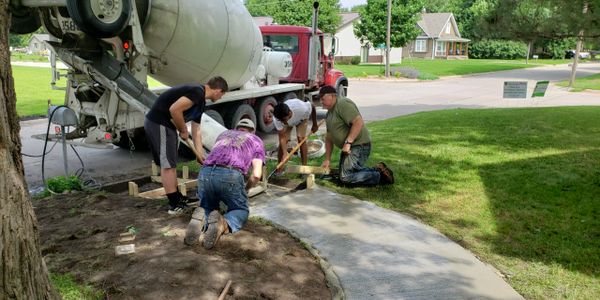 Workers pouring concrete for a walkway
