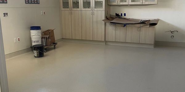 Homogeneous sheet vinyl with integral cove base and welded seams in medical facility.