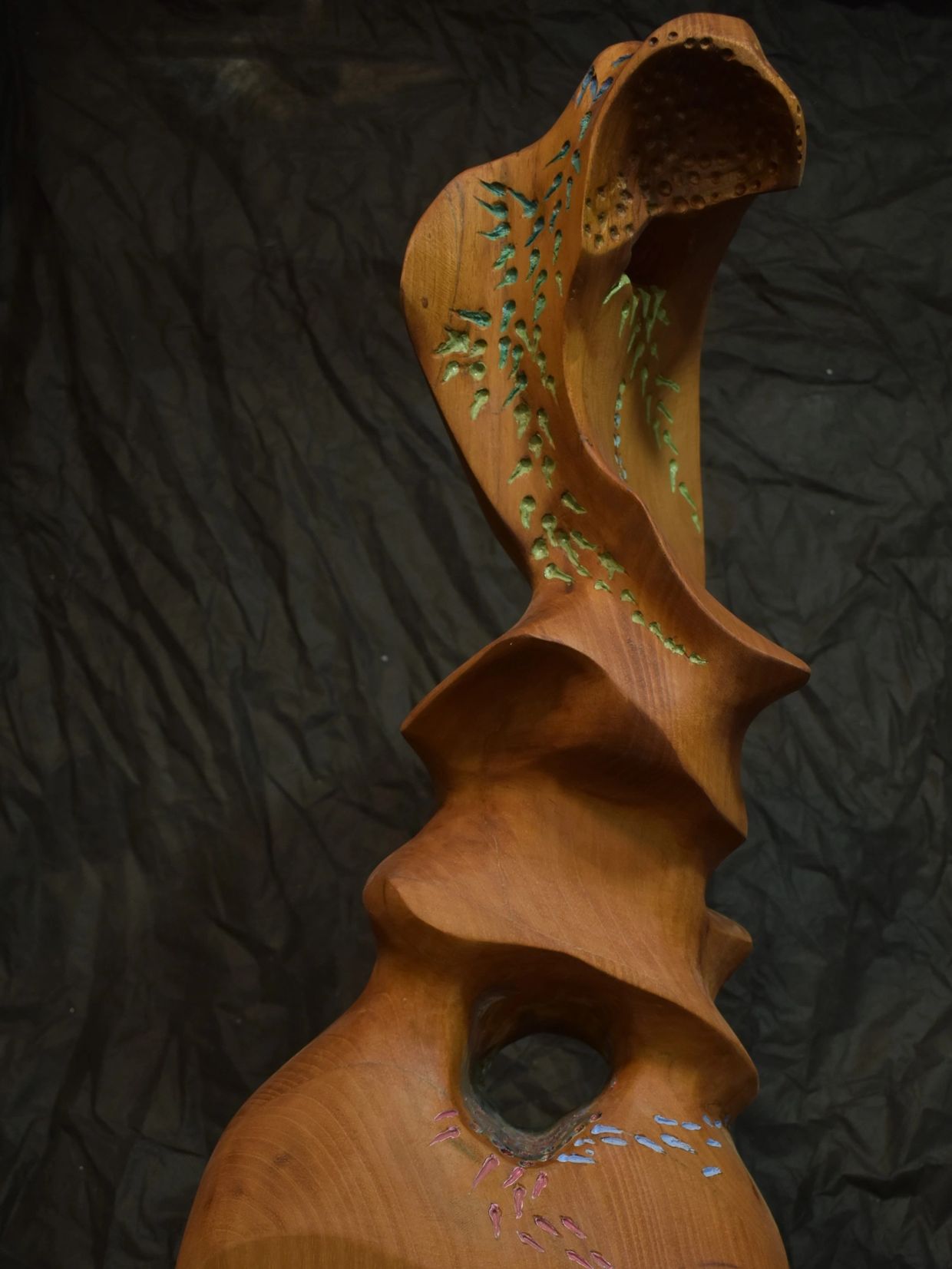 Escultura de madera con detalles tallados y pintados.