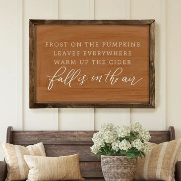 Cozy fall-themed wall decor with a wooden bench and floral arrangement.
