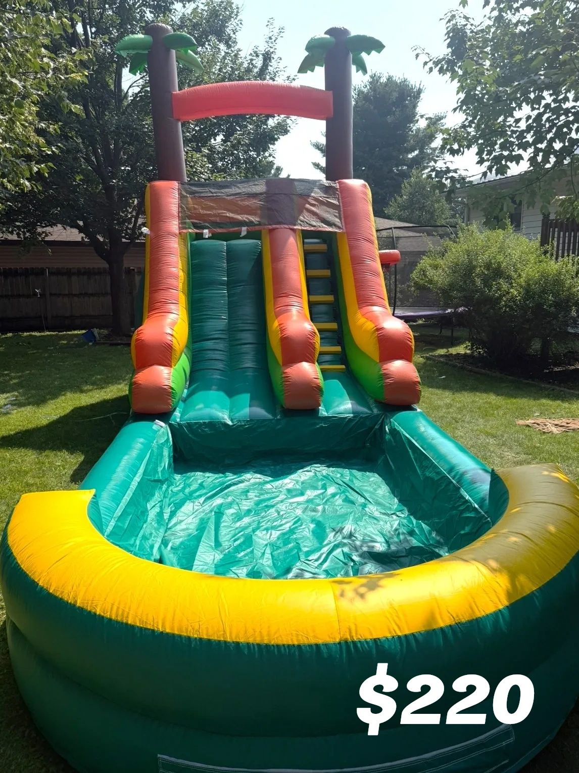 Colorful inflatable water slide with pool, priced $220.