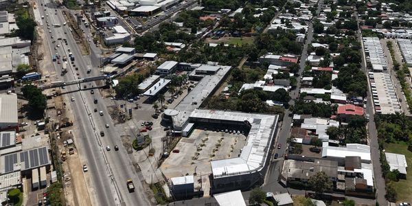 Aerial view of a busy highway next to residential and commercial buildings.