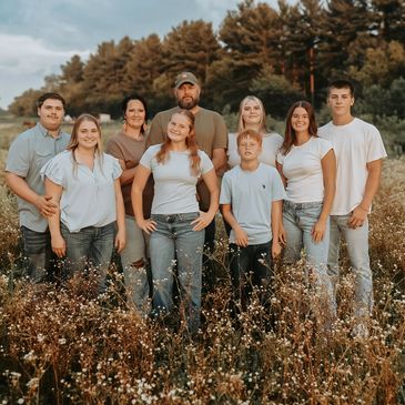 Family portrait in a wildflower field during golden hour.