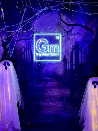 Halloween-themed scene with ghosts and neon sign.