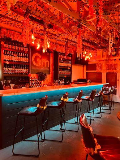 Cozy bar with hanging lights and decorated chairs.