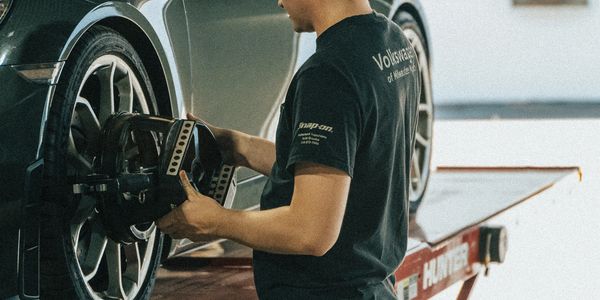 Factory trained Porsche automotive technician performing suspension alignment on Porsche 718 Boxstern