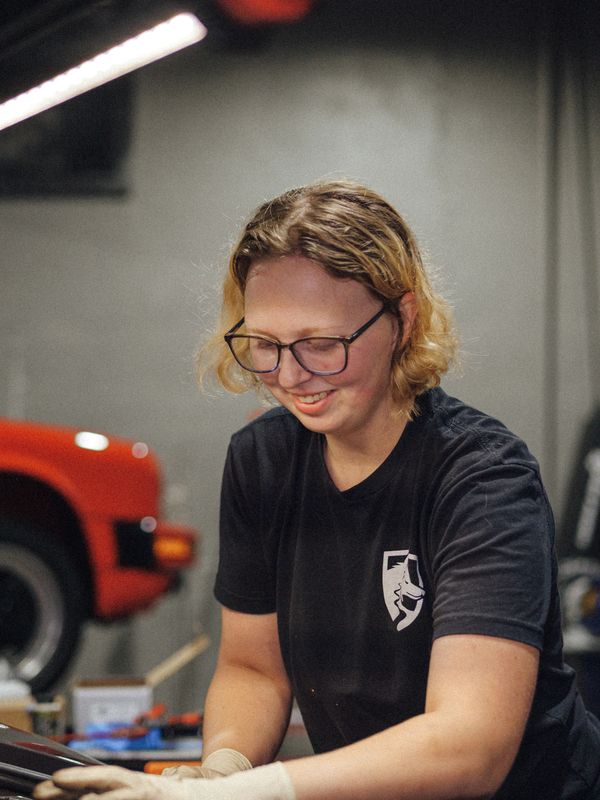 Porsche junior technician working on a Porsche Cayenne engine repair at Wolfpen in Roswell, Georgia