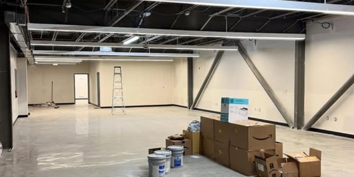 Empty industrial space with boxes and ladder, under construction or renovation.
