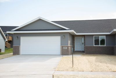 Modern single-story house with grey siding and a two-car garage.