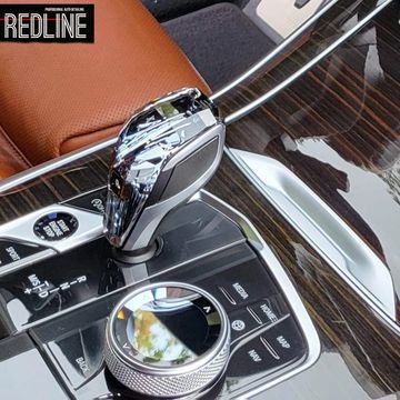 Close-up of a luxury car's gear shift and control panel.