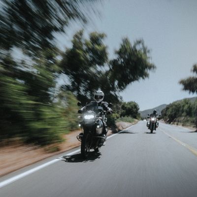 Two motorcyclists riding on a curvy road.