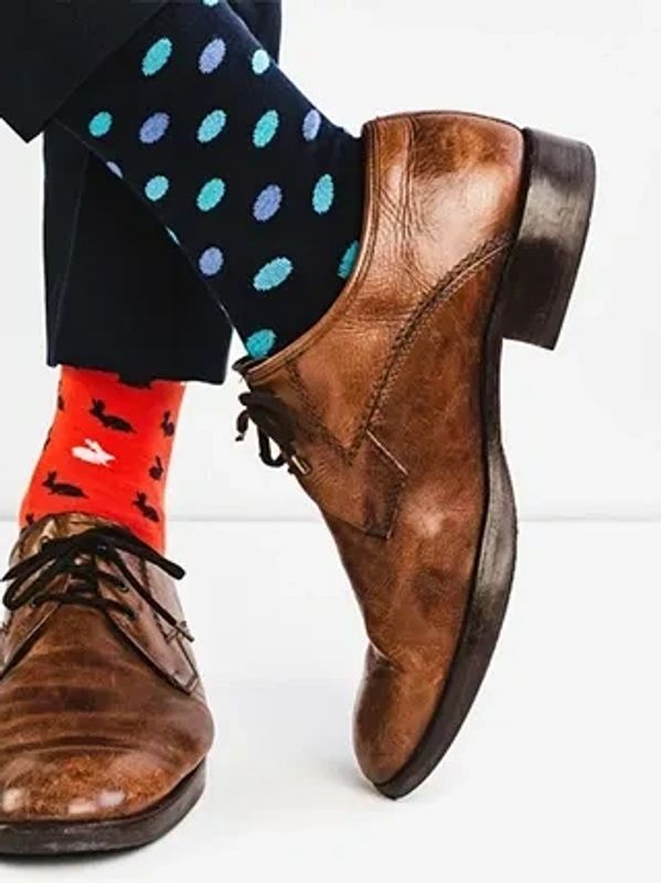 Chaussettes dépareillées avec chaussures en cuir marron.