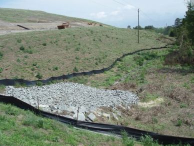 Land area with rocks and erosion control fabric.