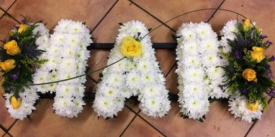 Funeral tribute letters in white flowers