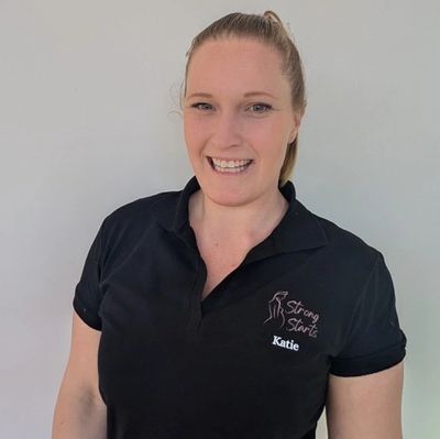 Smiling woman in a black polo shirt embroidered with 'Strong Starts' and 'Katie'.