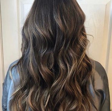Woman with long dark wavy hair.