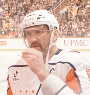 Close-up of a hockey player in white gear on the ice.