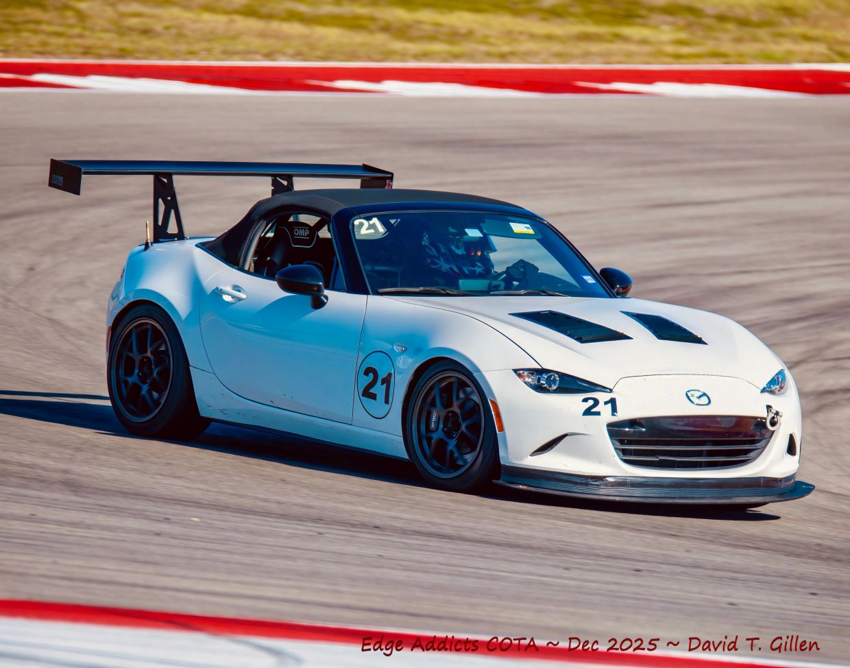 White Mazda race car on track with number 21.