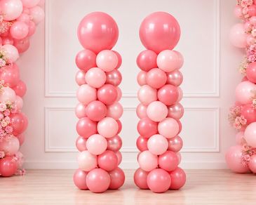 Two tall balloon columns in shades of pink for decoration.