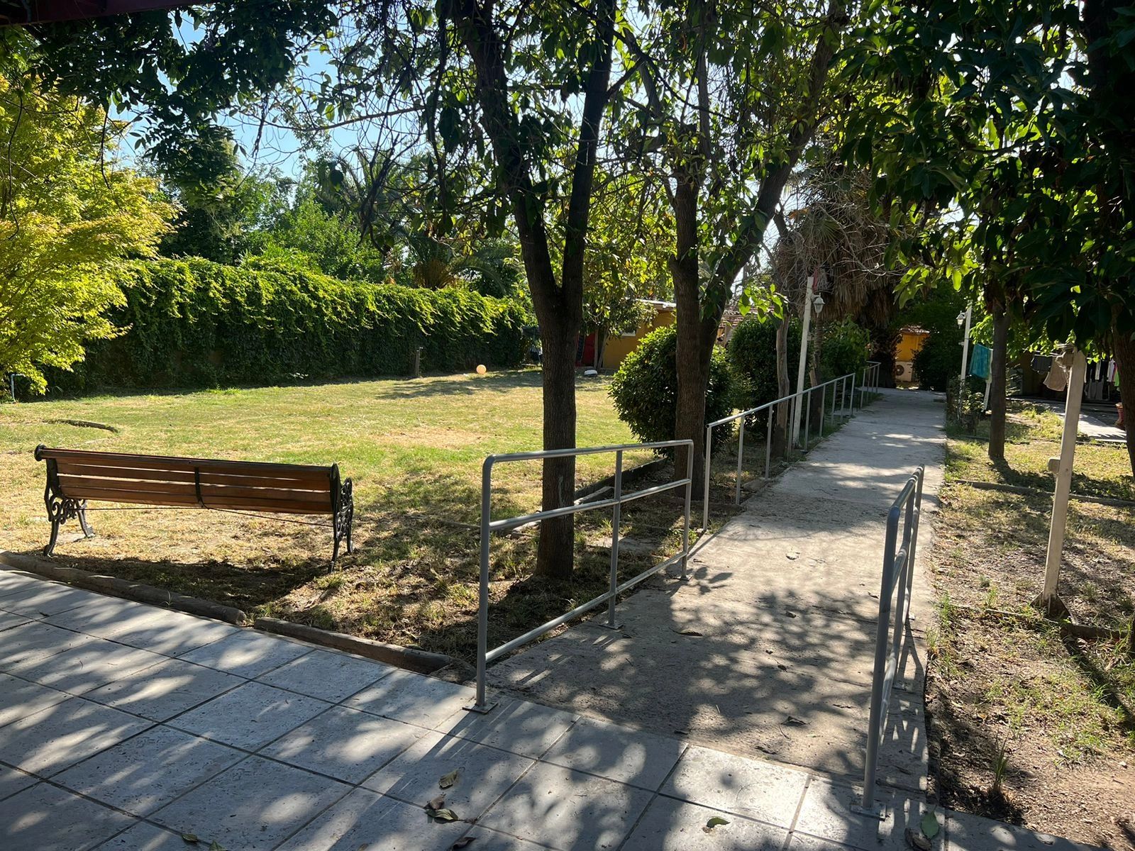 <img src="jardin.jpg" alt="Jardín al aire libre en el Hogar de Ancianos Nenita y Rosario con banco y sendero seguro, ideal para el cuidado adulto mayor">
