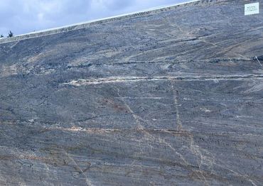 Polished slab of natural stone with intricate veining patterns.