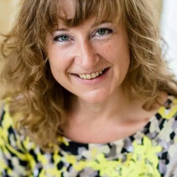Portret van een glimlachende vrouw met golvend haar.