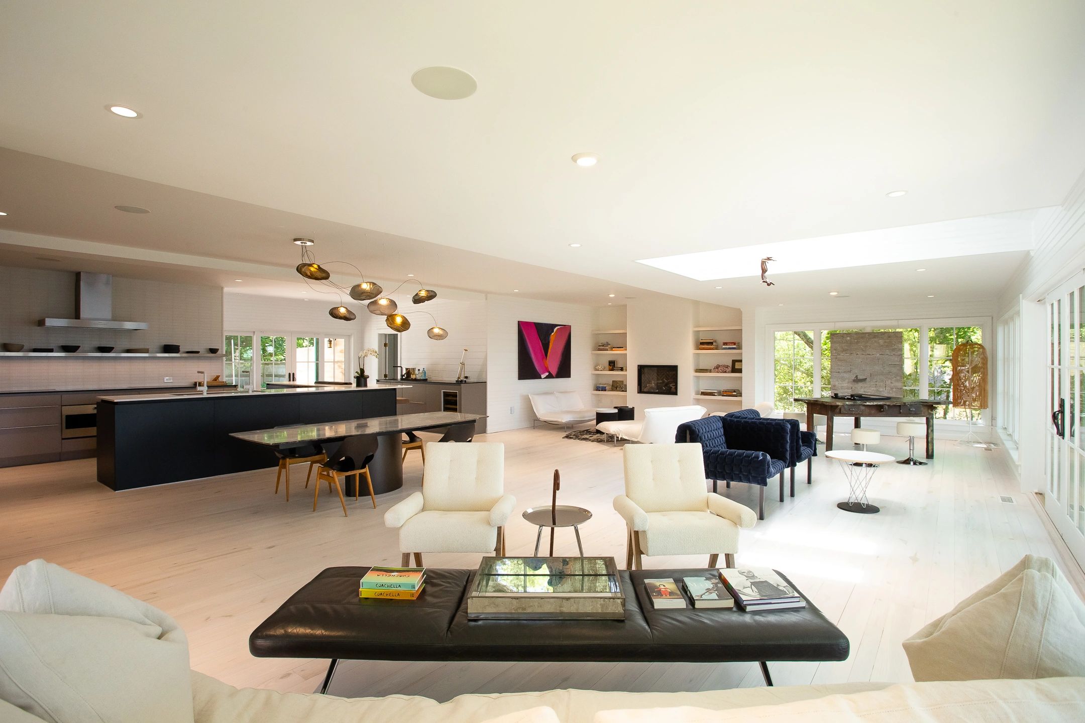 Spacious modern living room with kitchen and skylight.