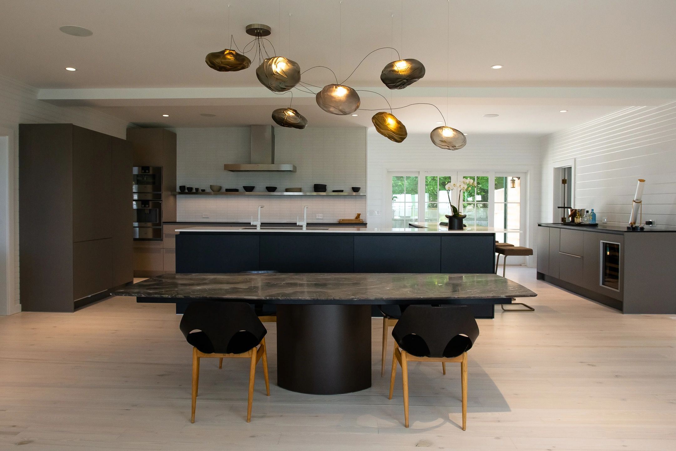 Modern kitchen with unique ceiling lights and marble table.