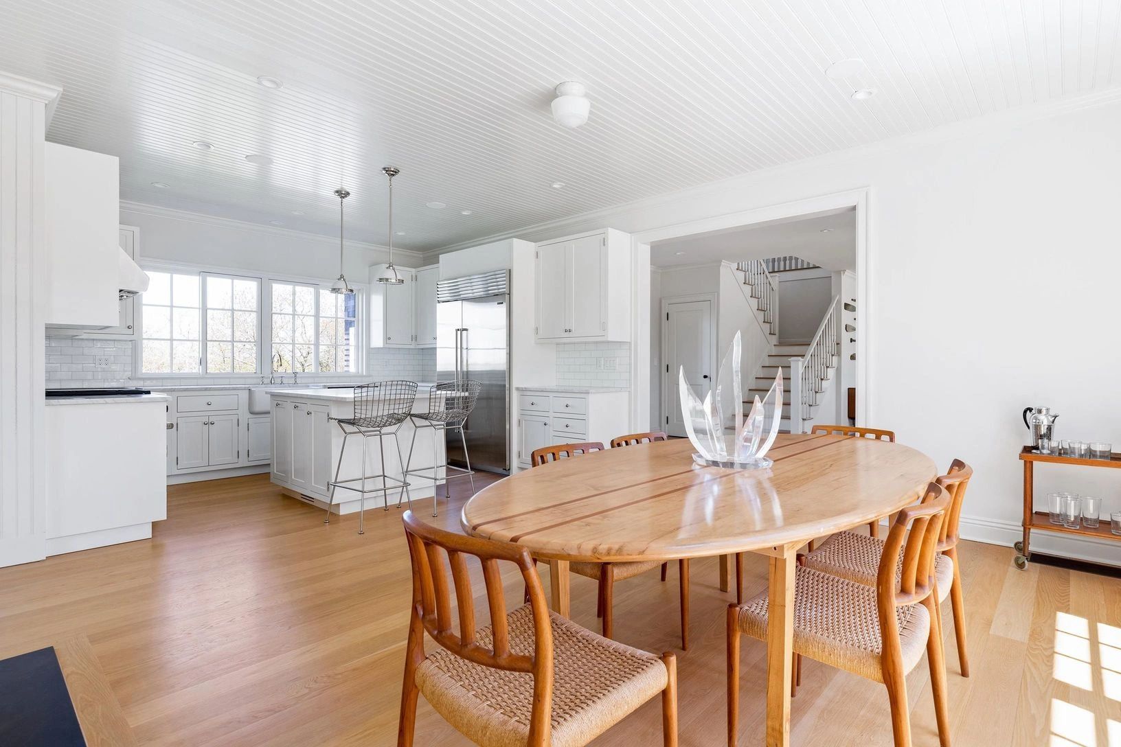 Bright modern kitchen and dining area with wooden furniture.