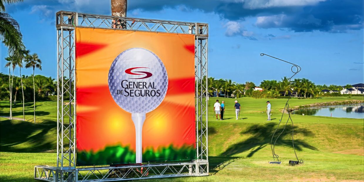 Golf course with General de Seguros advertisement and golfers.