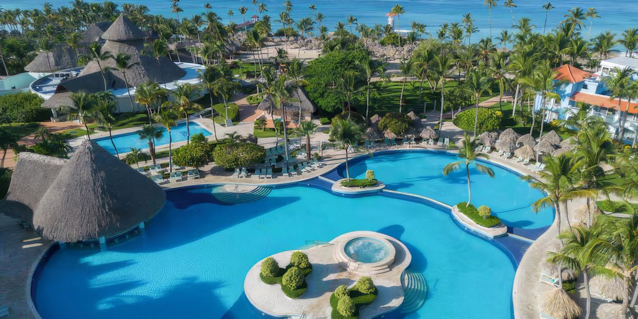 Tropical resort with large pool and palm trees.