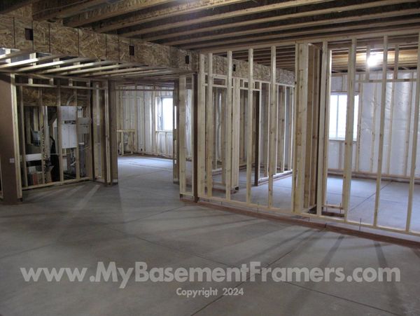 Basement framing of walls and soffit around steel beam with access for electrical wiring.