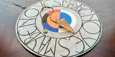 Pendulum resting on a circular divination board.