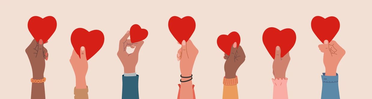Diverse hands holding red hearts symbolizing love and unity.