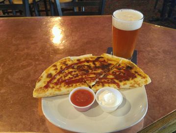 Cadillac Quesadilla on table with sauces and a beer