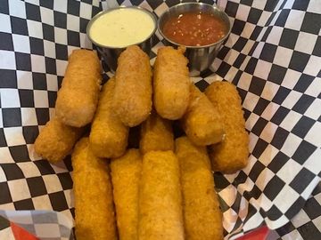 Mozzarella cheese sticks and marinara in a basket