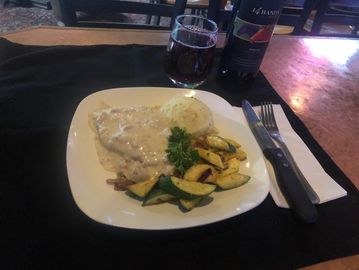 Chicken fried steak with potato and veggies on a plate