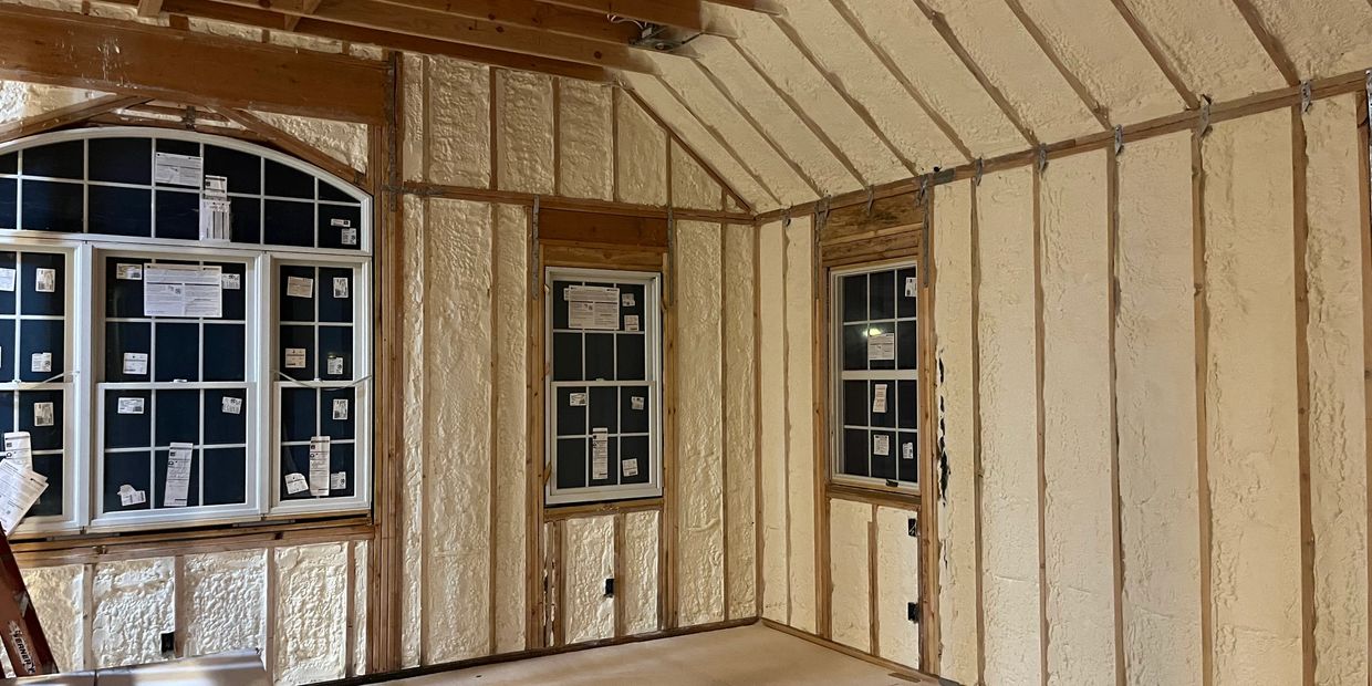 Room interior with spray foam insulation on walls and ceiling.