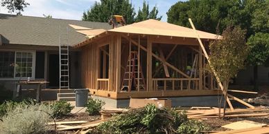 House under construction with wooden framing and roof structure.