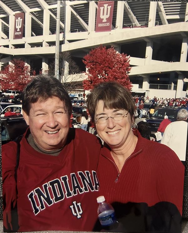 Smiling couple at Indiana University stadium tailgate.