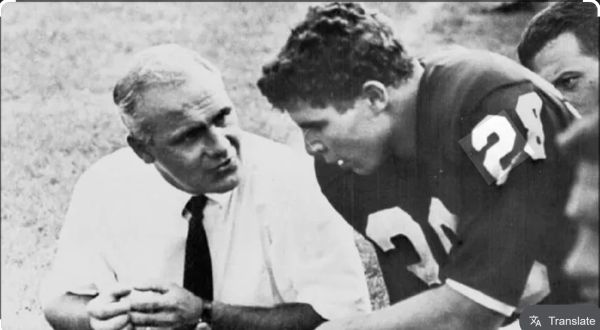 Coach talking to football player during a game.
