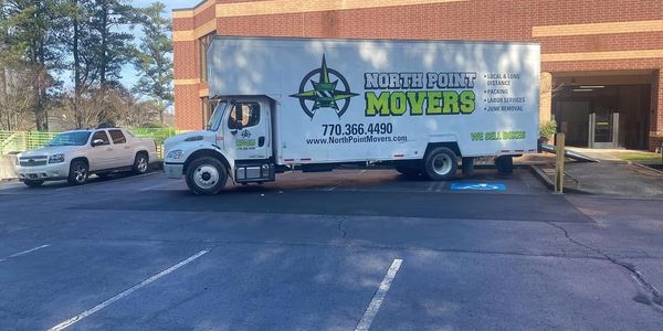 Professional movers carefully handling office equipment and furniture during a business relocation, showcasing reliable moving solutions for a stress-free move.